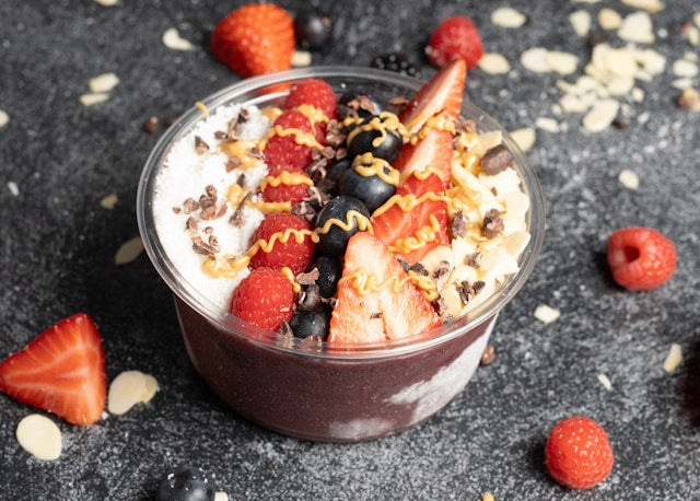 bowl of acai topped with fruit, nut butter, and other toppings.
